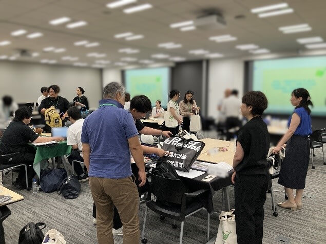 参加者が持ち寄ったグッズを見ながら話している様子