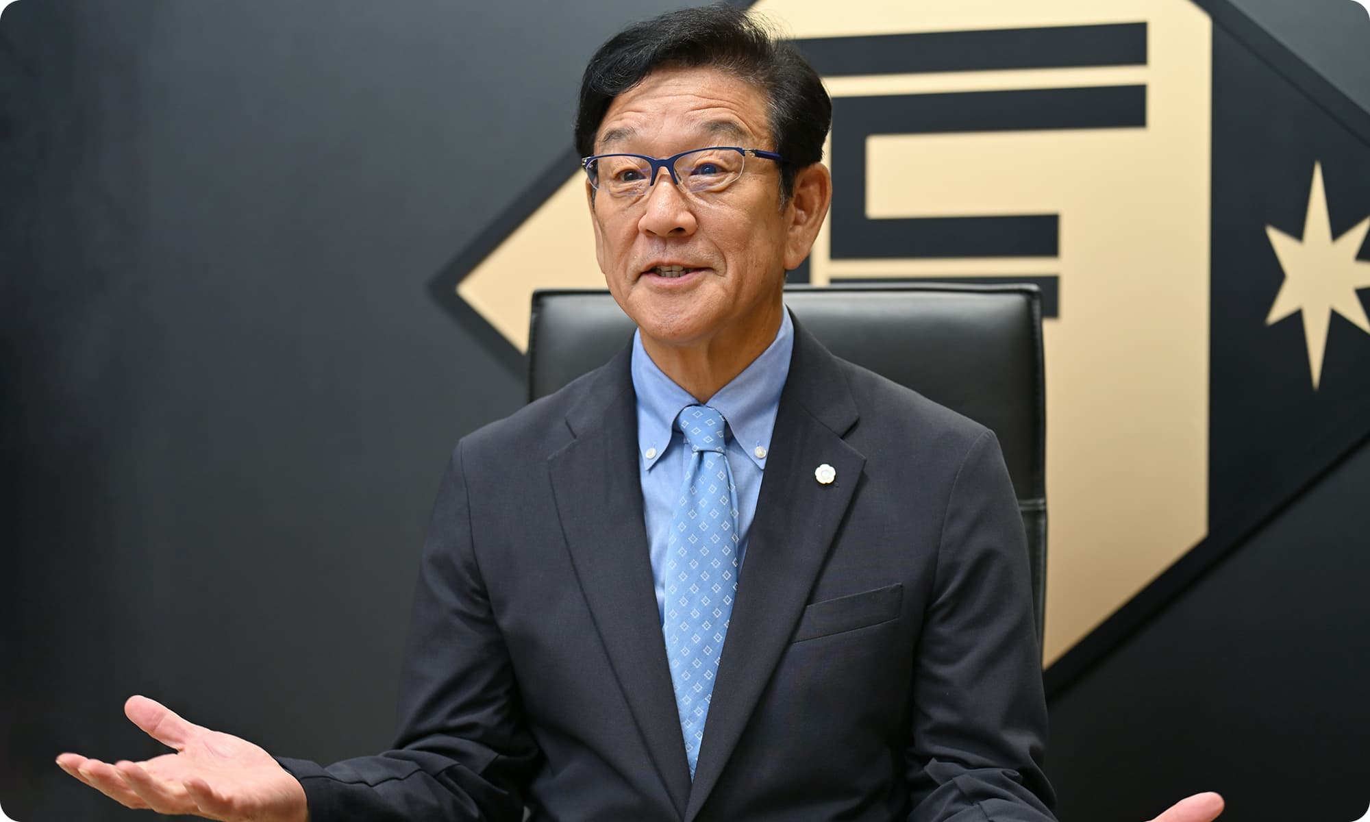 栗山英樹さんが両手を広げて話す様子