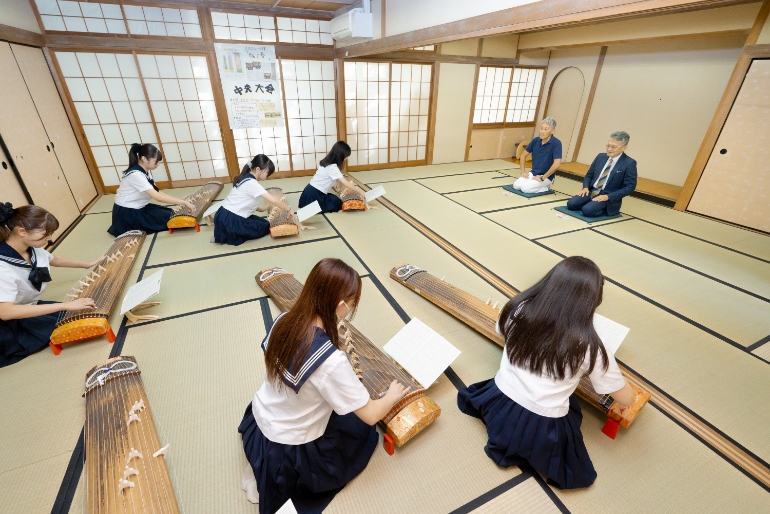 平井さんを琴の演奏で歓迎する同校の生徒たち写真