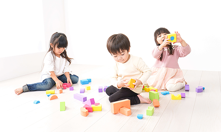 子どもたちが屋内で積み木をして遊んでいる様子の写真
