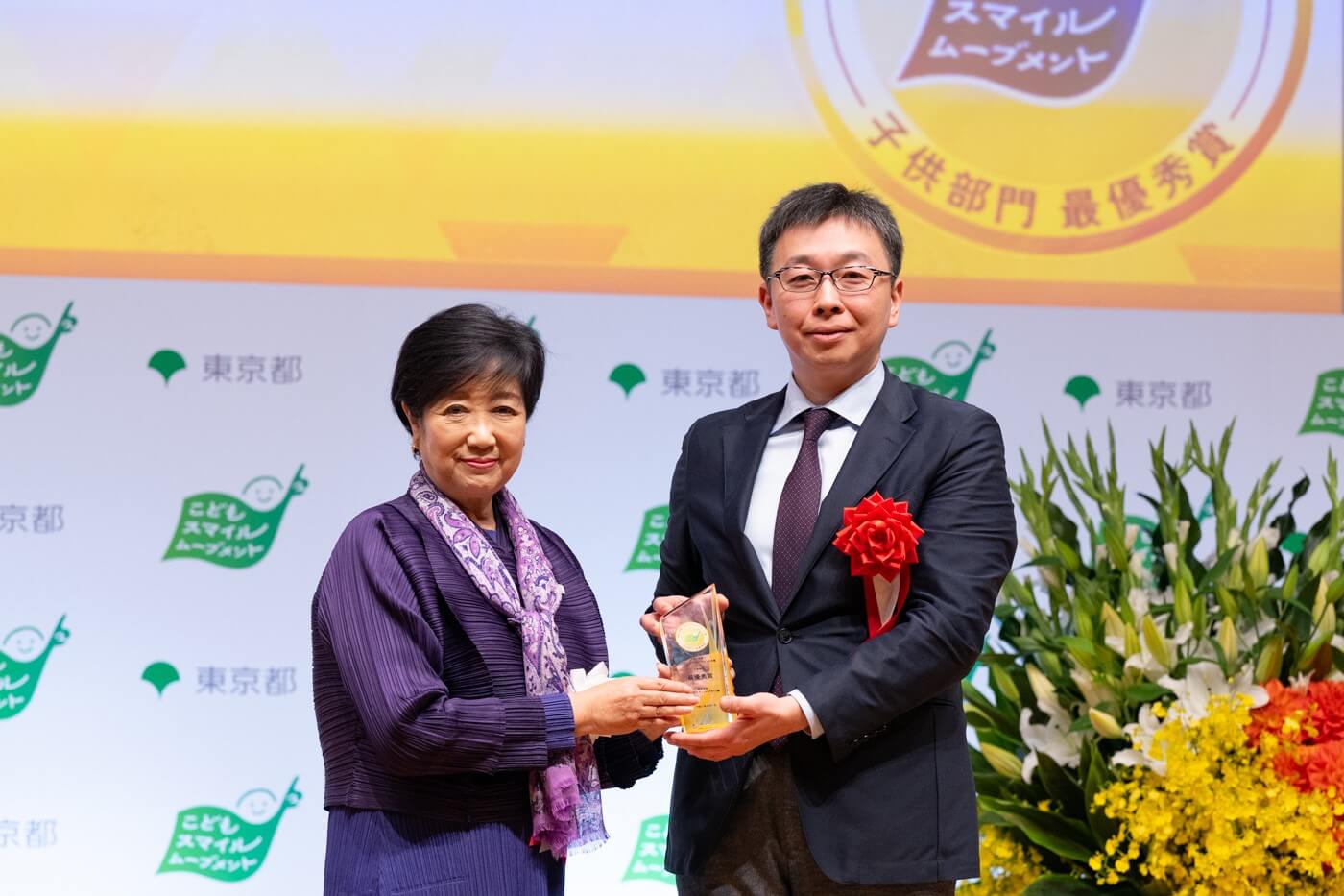 株式会社三井住友フィナンシャルグループの代表者が小池百合子都知事から最優秀賞の盾を受け取っている様子