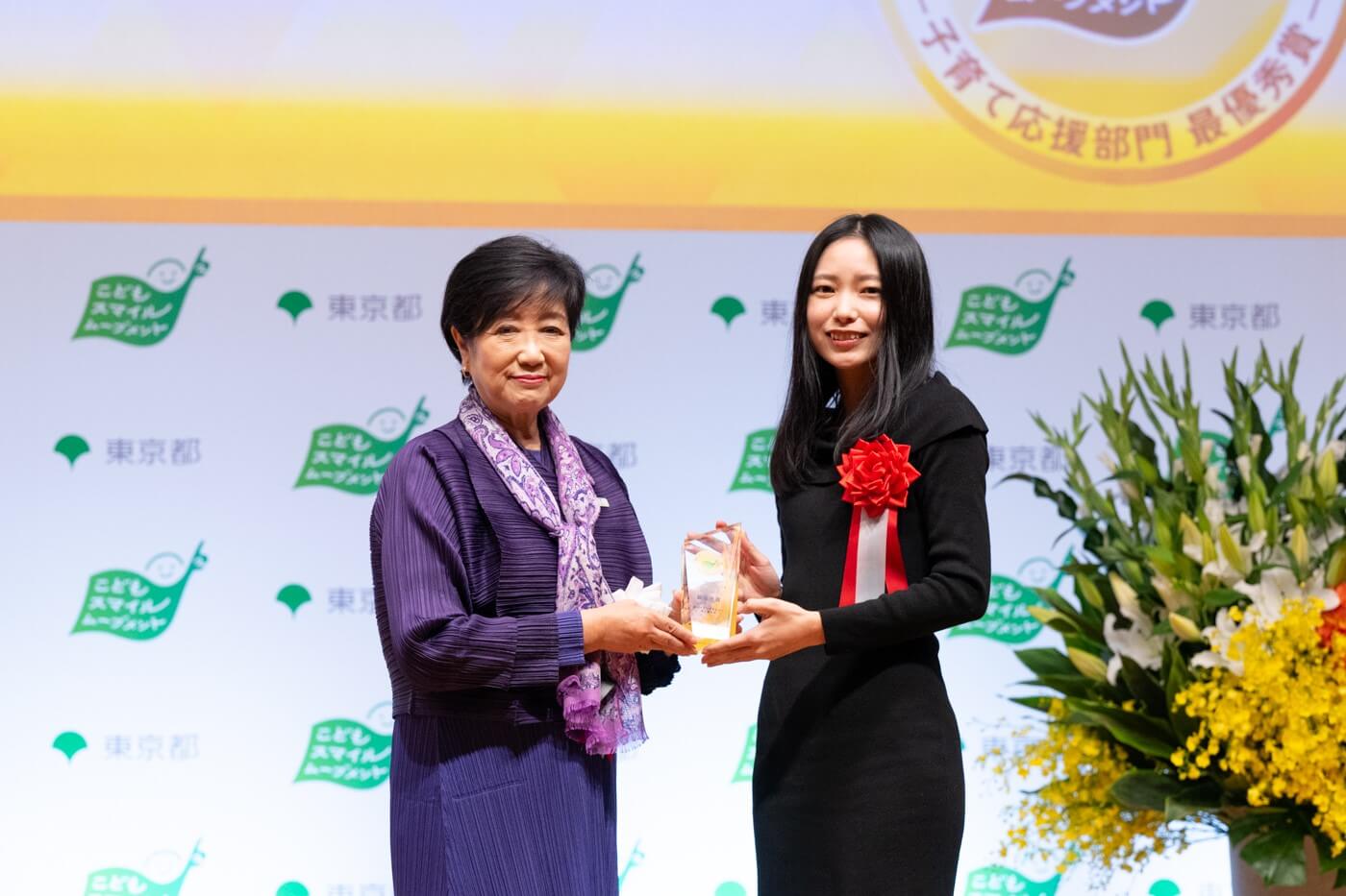 スパイスファクトリー株式会社の代表者が小池百合子都知事から最優秀賞の盾を受け取っている様子