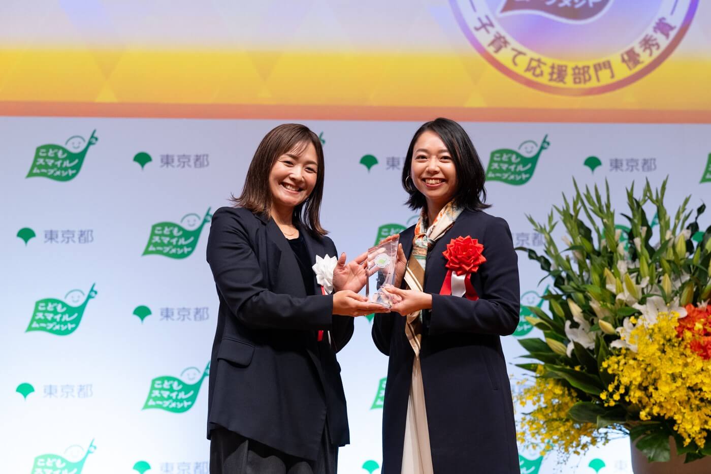 株式会社おりおりの代表者がこどもスマイルムーブメントアンバサダーの谷真海さんから優秀賞の盾を受け取っている様子