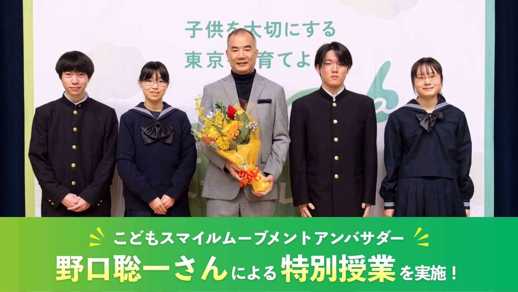 数人の生徒と並び、花束を持つ野口聡一さん