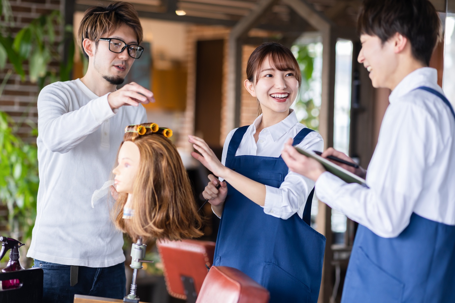 サロンでヘアセットの練習をしている男女3人の写真
